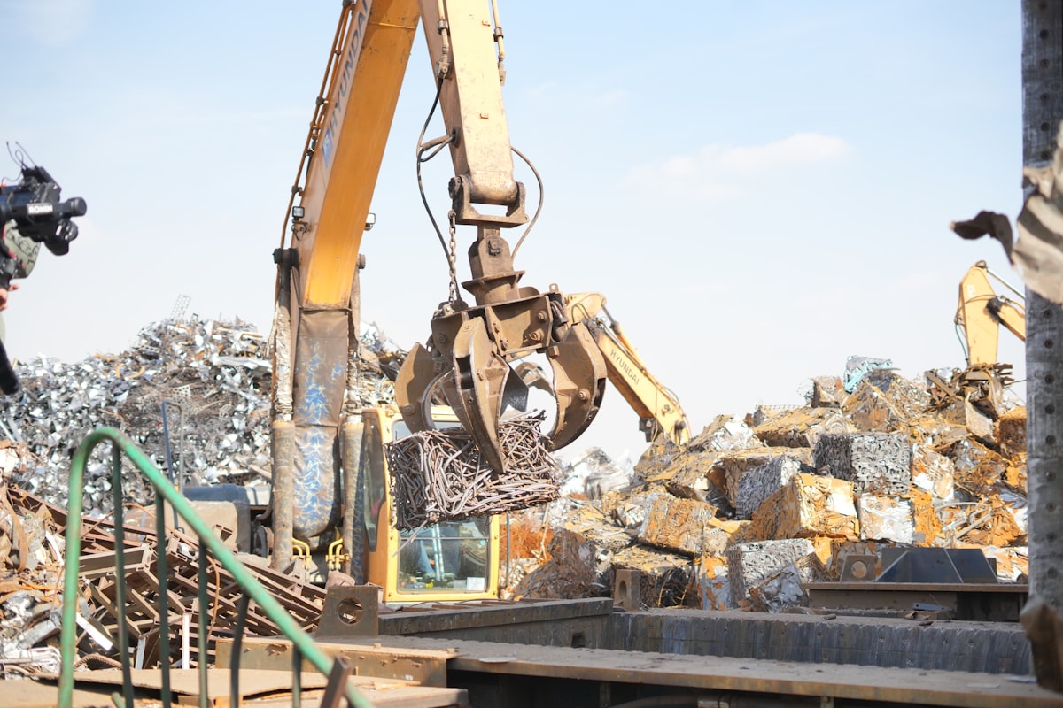 Kraan die schroot en oud metaal verlaadt op een recyclagesite